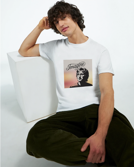 Studio flat-lay of Imagine tee styled with Beatles album and coffee