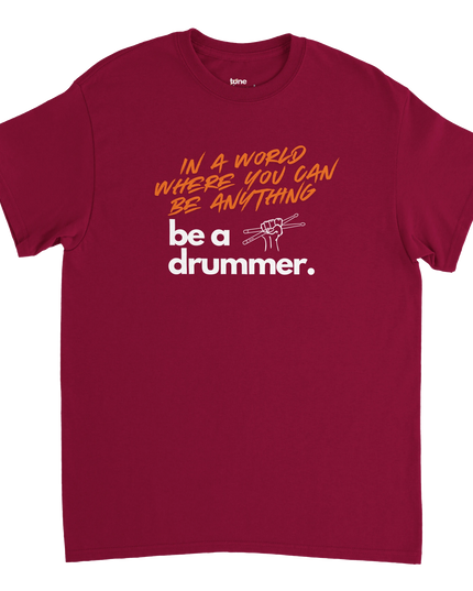 Overhead flat-lay of folded T-shirt next to a snare drum and headphones
