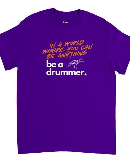 Flat‑lay of One Love shirt next to sheet music and a guitar pick